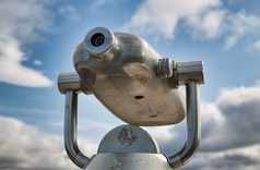 双筒望远镜与城市视图和天空的背景