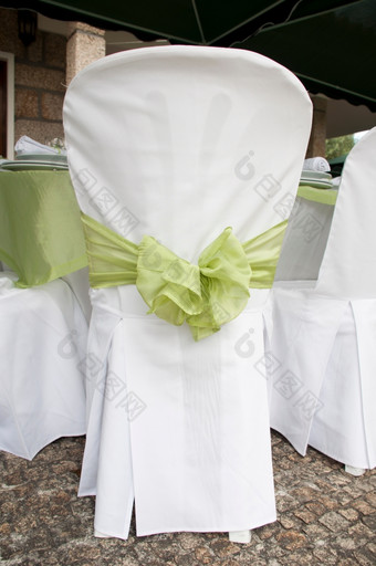 华丽的婚礼椅子装饰与绿色丝带在户外