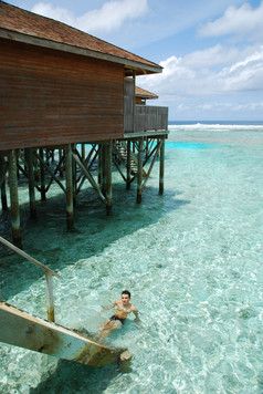 年轻的成人放松半透明的水马尔代夫的岛