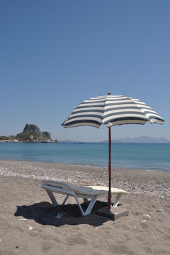 华丽的海滩场景与希腊伞而且椅子Kefalos海滩食物希腊
