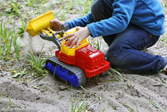 孩子们玩的新鲜的空气孩子坐在在沙子和草的图像的小孩子谁坐在和戏剧与大玩具车的沙子