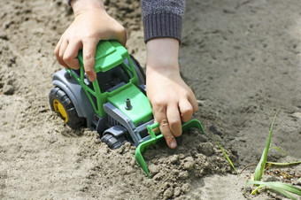 孩子们玩与玩具在户外的孩子坐在在的沙子的图像的<strong>小孩子</strong>谁坐在和戏剧与绿色玩具铲的沙子