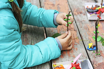 孩子玩在户外的图像部分小孩子玩与橡皮泥的街后面的桃花心木桌子上孩子戏剧与粘土和各种各样的自然材料与不同的形状女孩造型橡皮泥走