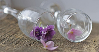 的花是紫罗兰花backgroundthe花的玻璃几小紫罗兰色的花透明的玻璃眼镜眼镜的木表面