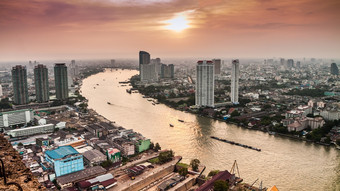 高视图曼谷城市与现代建筑而且内陆水运输沿着Chaopraya河晚上