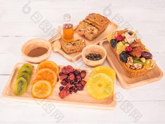 面包<strong>水果蛋糕</strong>和干<strong>水果</strong>与蜂蜜甜胡椒肉桂木板和碗白色背景