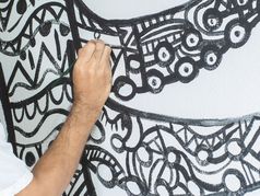 特写镜头艺术家绘画摘要模式章鱼形状白色水泥墙丙烯酸颜色