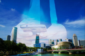 蓝色的天空和业务建筑城市与商人使用智能手机背景为连接的世界