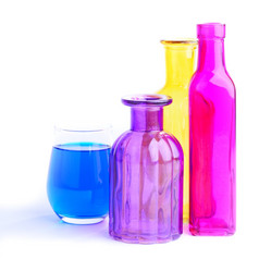三个色彩斑斓的瓶而且一个玻璃孤立的白色背景