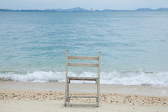 白色木椅子放置的沙子海滩的海