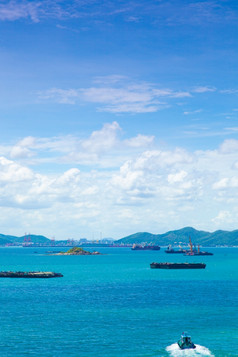 货物船只停泊的海附近的岛的明亮的天空的白天