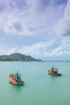 小钓鱼船停泊的海后面的山而且树