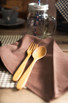 木勺子而且叉放置的餐巾集的表格