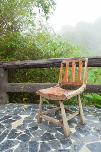 木椅子的阳台装饰使石头的外阳台树潮湿的空气