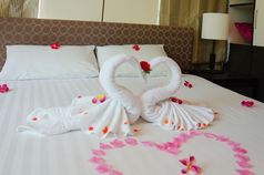 室内卧室天鹅毛巾和兰花花的床上的酒店房间是浪漫的为夫妻