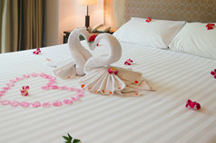 室内卧室天鹅毛巾和兰花花的床上的酒店房间是浪漫的为夫妻