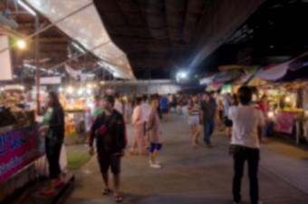 摘要模糊人走食物摊位晚上市场节日为背景使用