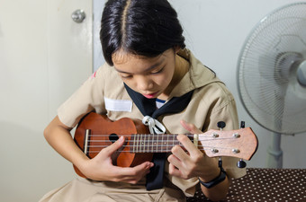 女孩手玩尤克里里琴尤克里里琴有获得了很多<strong>受欢迎</strong>程度尤克里里琴最终改变了从本地的夏威夷仪器国际仪器