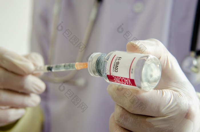 医生手套是持有的注射器和疫苗瓶疫苗对冠状病毒新冠病毒