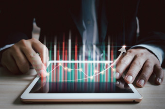 业务策略金融和数字市场营销商人使用平板电脑分析销售数据和经济增长图表