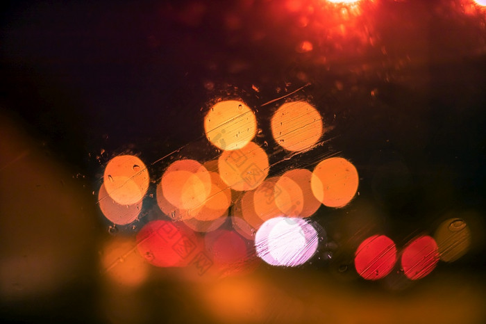 摘要散景模糊背景雨滴玻璃窗口晚上的城市