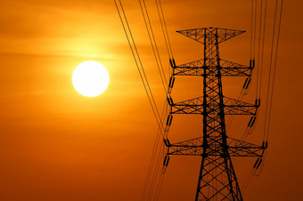 轮廓高电压电塔与美丽的日落背景