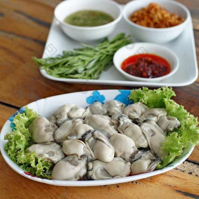 新鲜的牡蛎与一边菜木桌子上