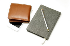 笔记本与笔智能手机和棕色（的）皮革钱包孤立的白色背景