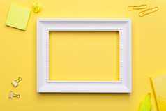 白色框架和办公室配件黄色的背景平躺复制空间前视图
