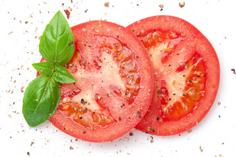 切片红色的西红柿撒与新鲜地面胡椒超过与绿色罗勒叶孤立的白色背景视图从以上平躺切片红色的西红柿撒与地面胡椒