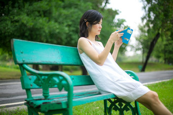 亚洲女人使用移动聪明的电话的公园