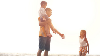幸福父亲和儿子和女儿玩的海滩