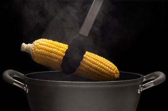 热玉米从能与蒸汽黑色的背景