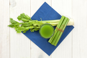 绿色蔬菜汁与芹菜白色木背景