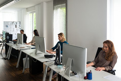 年轻的团队工作电脑桌子时尚的办公室与概念上的论文的背景可能启动有创意的办公室