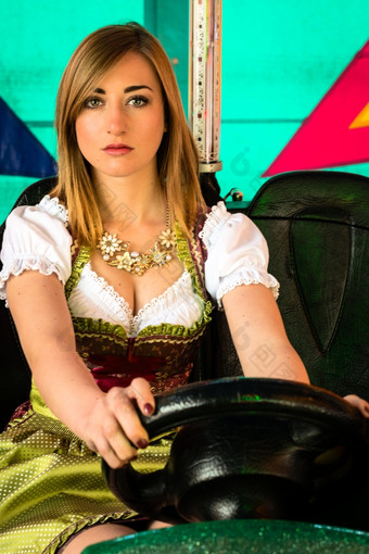 美丽的女孩电保险杠车娱乐公园美丽的女孩电保险杠车娱乐公园典型的德国迪恩德尔衣服与明亮的颜色而且灯的背景