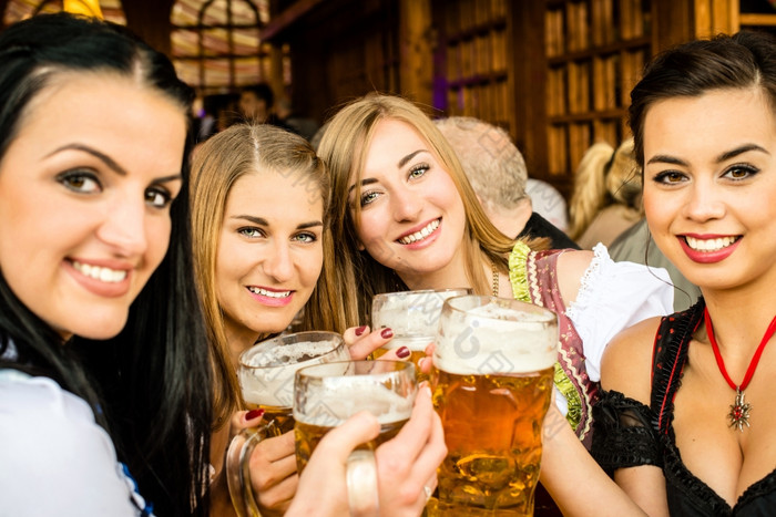 女孩传统的迪恩德尔礼服是喝啤酒而且有有趣的的啤酒节混合比赛一个亚洲一个俄罗斯两个高加索人女孩