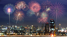 色彩斑斓的烟花模糊摩天大楼与城市散景灯照亮晚上摘要新一年假期聚会，派对背景