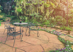放松区域田园绿色花园放松区域田园绿色花园与花岗岩表格和金属椅子古董过滤后的语气图像