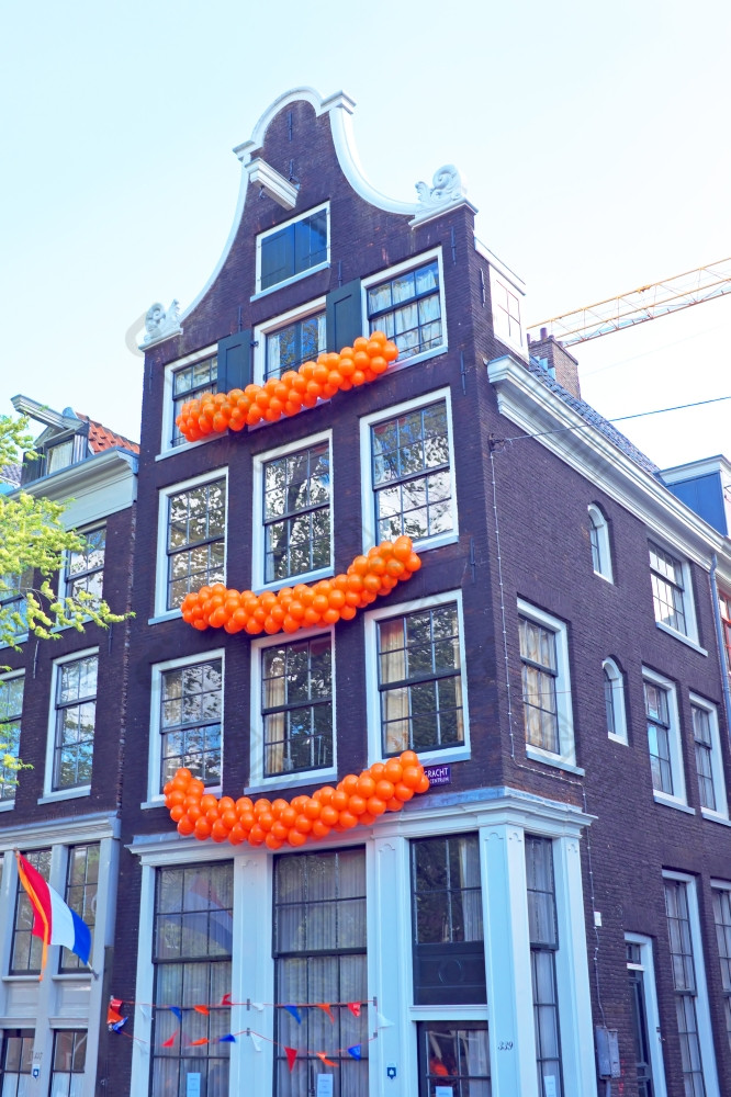 传统的荷兰房子装饰与旗帜而且气球Kingsday阿姆斯特丹的荷兰