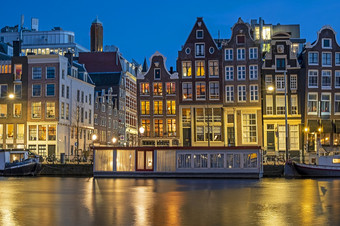 阿姆斯特丹房子和房子船沿着的阿姆斯特尔阿姆斯特丹的荷兰日落