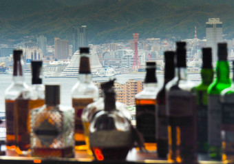 日本科比4月科比塔和城市天际线与模糊威士忌瓶酒吧计数器科比城市天际线与模糊威士忌瓶