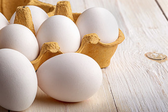 白色鸡蛋附近纸托盘白色表格特写镜头鸡蛋附近的托盘白色表格特写镜头