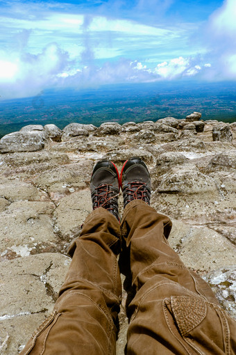腿但休息靴子为山跟踪对的背景山和山谷与嘈杂的云徒步旅行靴子的山休息时间自由概念