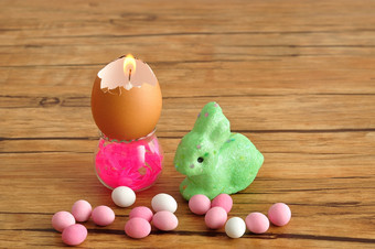 空蛋壳牌那转成蜡烛显示小容器与绿色兔子和粉红色的和白色糖果为复活节