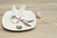 复活节的地方设置与的餐巾的形状兔子耳朵显示与板刀叉勺子和碗糖果