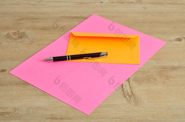 粉红色的纸和橙色信封与黑色的笔