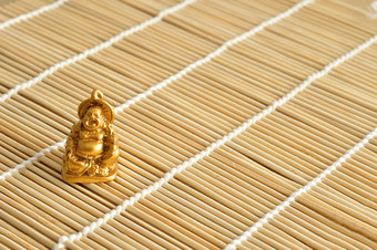 小雕像笑和快乐的金佛孤立的竹子背景