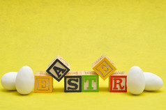复活节拼写与色彩斑斓的字母块显示与白色复活节鸡蛋