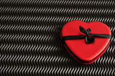 情人节一天红色的心系与黑色的丝带孤立的对黑色的背景
